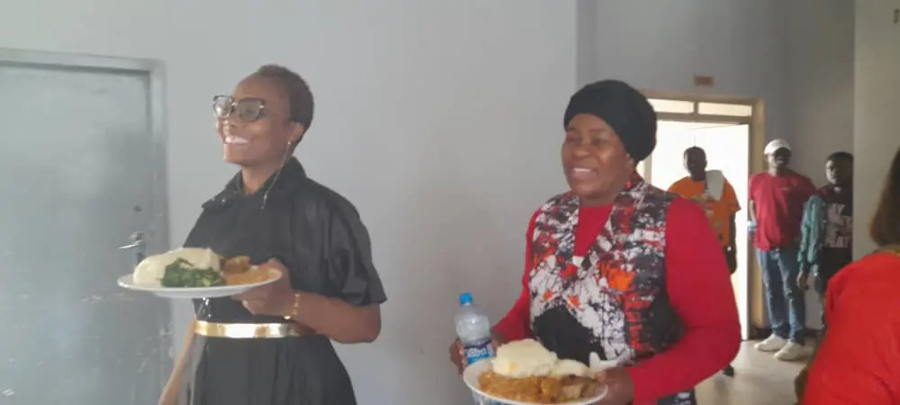 Attendees of the RAAZ Ministers Fellowship taking their food to a table to together Attendees of the RAAZ Ministers Fellowship taking their food to a table to together